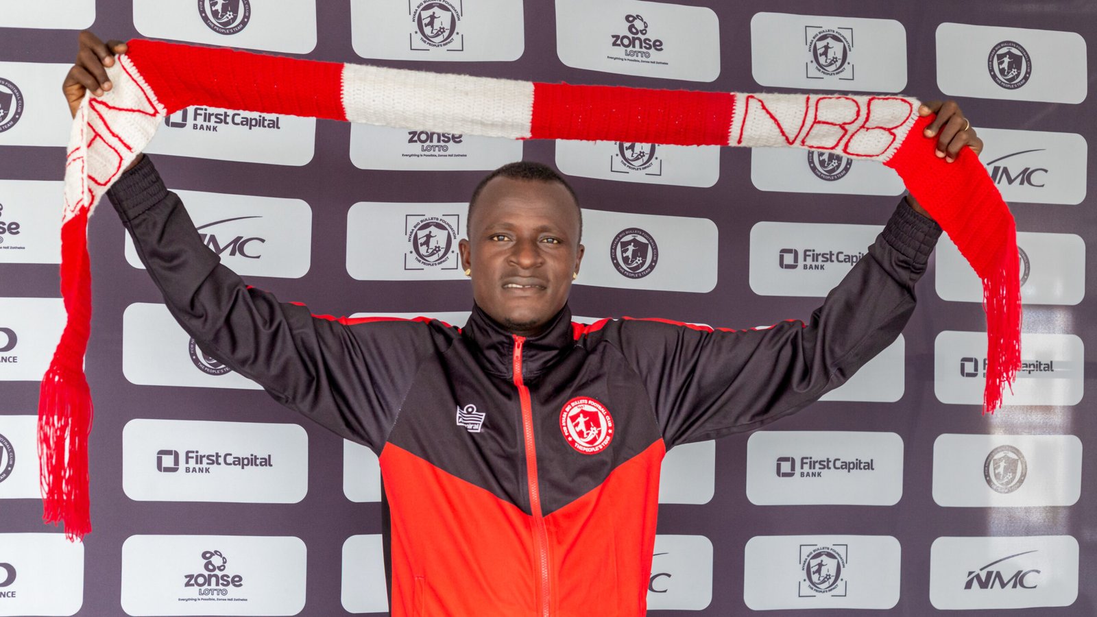 Sheku Sheriff holds an FCB Nyasa Big Bullets scarf during his unveiling at the club offices.