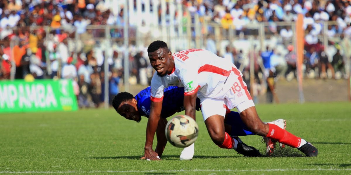 Babatunde Adepoju battles for the ball against Stanley Sanudi during the first-round Blantyre Derby at Kamuzu Stadium