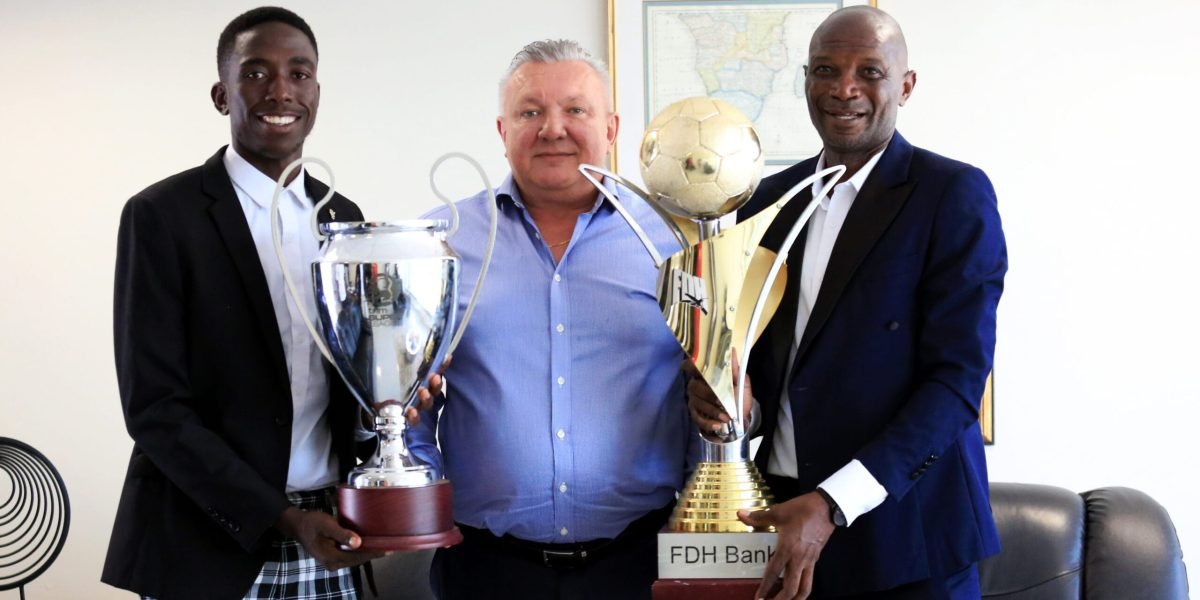FCB Nyasa Big Bullets head coach Kalisto Pasuwa and captain Precious Sambani presenting the FDH Bank Cup and TNM Super League to club president Konrad Buckle