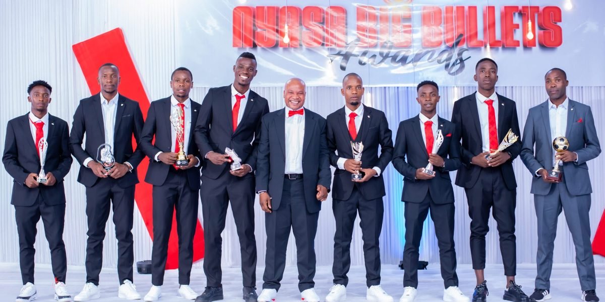 Nyasa Big Bullets CEO Suzgo Nyirenda poses with the winning players and assistant coach Peter Mponda